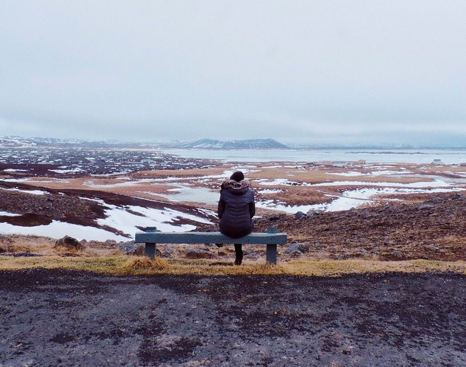 Sentada em um banco, admirando a paisagem