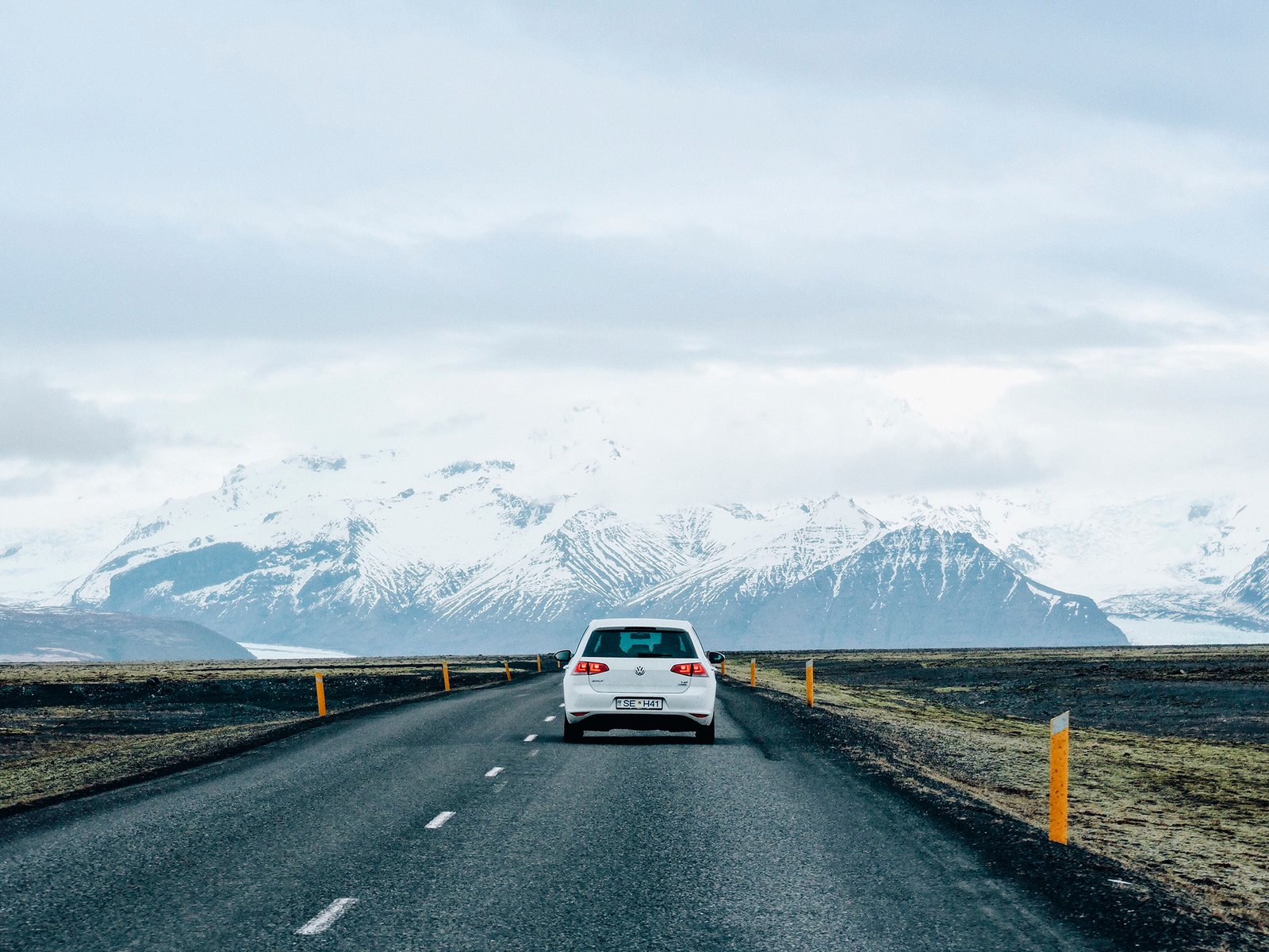 Carro na estrada e as montanhas ao fundo