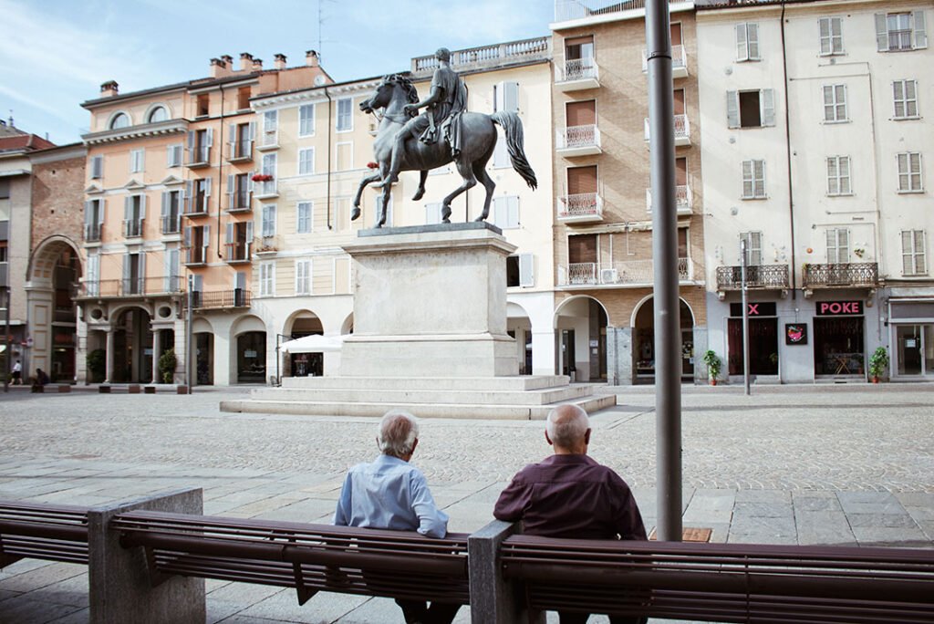 Casale Monferrato: dois senhores sentados observando uma linda praça vazia